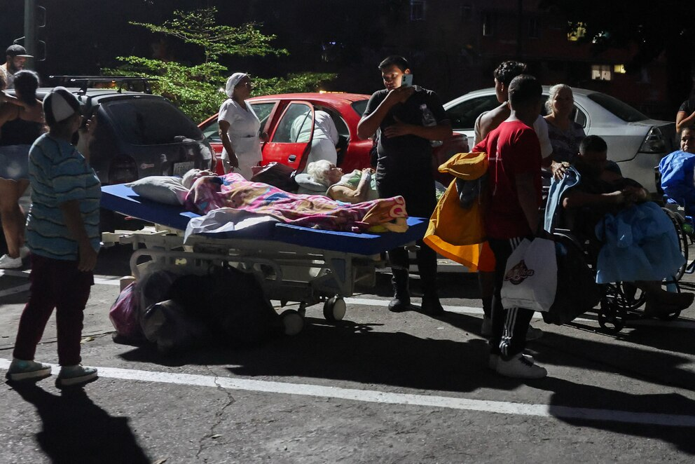 Várias pessoas estão com outras em cadeiras de rodas e camas de hospital nas ruas após um terremoto em Caracas, Venezuela, 24 de junho de 2026 REUTERS/Leonardo Fernandez Viloria